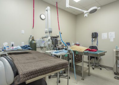 A room featuring a bed, chair, table, and medical equipment